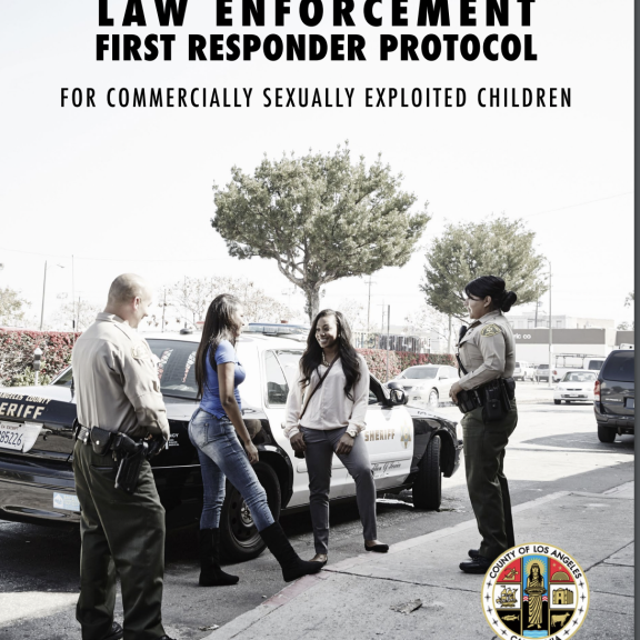 Two youth talking to two police officers on the street