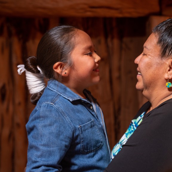 Native Child and Native adult look at each other happily