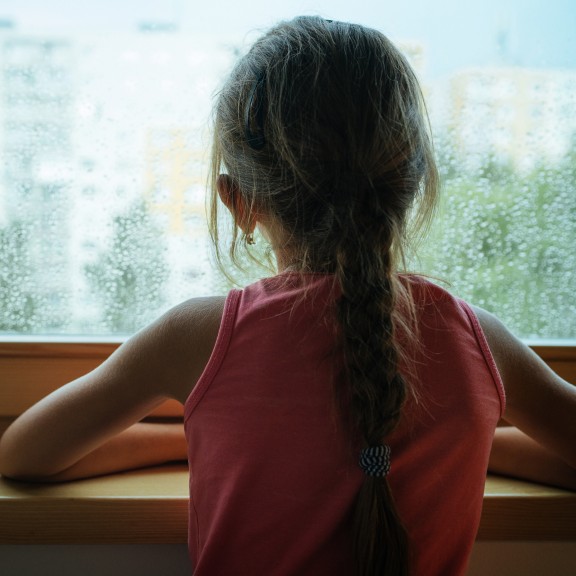 Child looks out a window