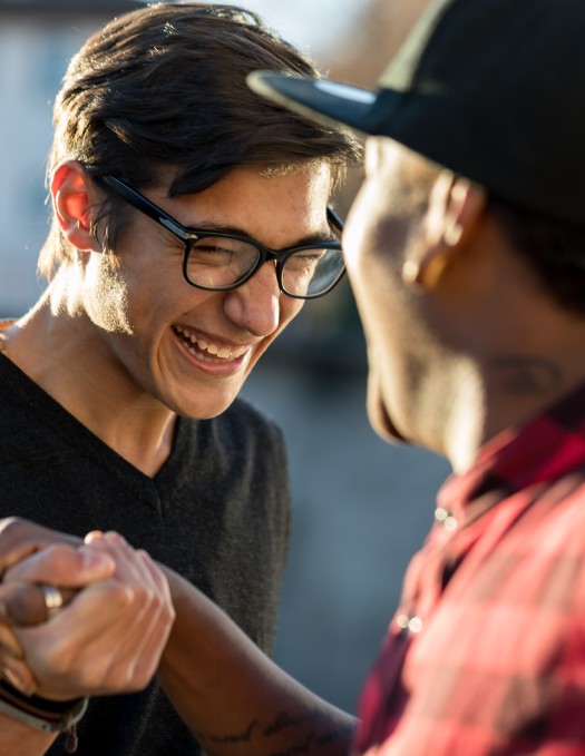 Two young people clasping hands in a greeting